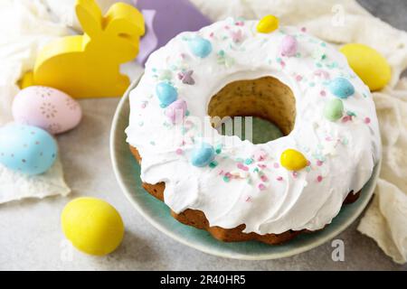 Buone feste di Pasqua, gustoso dessert. Torta di Pasqua glassata al limone decorata con dolciumi e mini caramelle di uova al cioccolato su gra Foto Stock