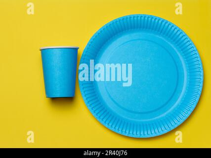 Piastre e tazze circolari monouso in carta blu per picnic, rifiuti riciclabili, vista dall'alto. Foto Stock