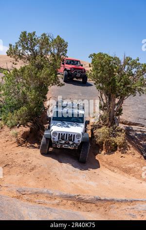 4WD Jeep manovrare giù un drop-off sul sentiero OHV Fins & Things vicino a Moab, Utah. Foto Stock