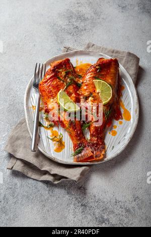 Cotta Red sea bass in kraft piastra bianca, concreto sfondo. Foto Stock