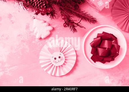 Colore trendy dell'anno 2023 - Viva Magenta. Sfondo di Natale con albero di Natale, scatole di regali e simbolo di anno cinese lunare Foto Stock