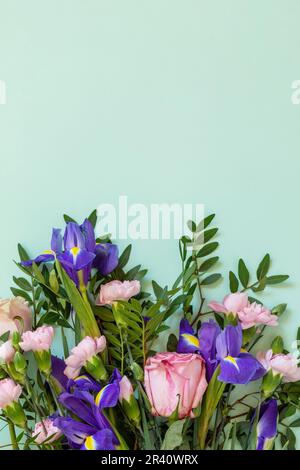 Giorno della madre o sfondo di compleanno. Primavera bel bouquet su sfondo verde. Vista dall'alto, disposizione piatta. Foto Stock