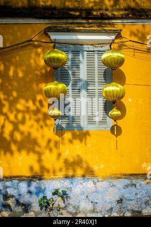 Casa tradizionale in Vietnam Hoi An con parete gialla, finestra blu chiaro e lanterne gialle. Foto Stock