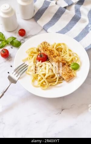 Spaghetti senza glutine con salmone alla griglia in formaggio cremoso su sfondo marmoreo. Spazio di copia. Foto Stock