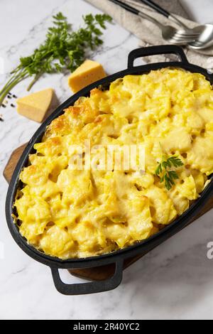 Patate gratinate, cucina francese. Sana casseruola o gratin con crema, gratin dauphinois su un tavolo di pietra grigia. Foto Stock