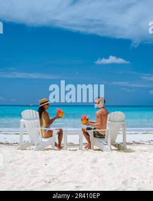 Coppia uomini e donne sulla spiaggia con bevanda di cocco, Praslin Seychelles isola tropicale con withe spiagge e palme, beac Foto Stock