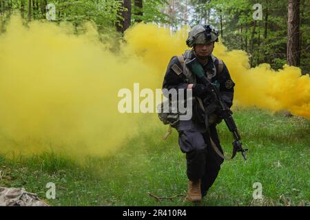 Hohenfels, Germania. 8th maggio, 2023. Trevor Mats-Brown, una medica di combattimento assegnata alla Brigata Medica del 348th, sprint attraverso uno schermo di fumo durante il Combined Resolve 18 presso Hohenfels Training Area, Joint Multinational Readiness Center, Germania, 8 maggio 2023. Combined Resolve 18 è un esercizio dell'Esercito composto da oltre 4.000 membri del servizio, alleati e partner di 15 paesi ed è progettato per valutare le capacità di condurre operazioni di combattimento in modo efficace in uno spazio di battaglia multidominio. (Credit Image: © U.S. Army/ZUMA Press Wire Service) SOLO PER USO EDITORIALE! Non per USO commerciale! Foto Stock