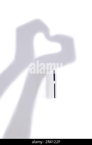Tubo bianco mock up per cosmetici e mani in ombra sulla parete. Foto Stock