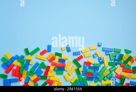 Cubi di plastica multicolore di un designer per bambini su sfondo blu, vista dall'alto Foto Stock