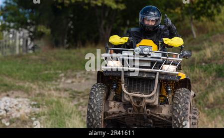 Guida avventurosa di moto ATV. Un uomo guida un quad su strade pericolose Foto Stock