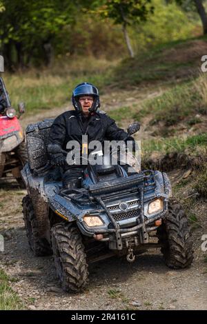Guida avventurosa di moto ATV. Un uomo guida un quad su strade pericolose Foto Stock