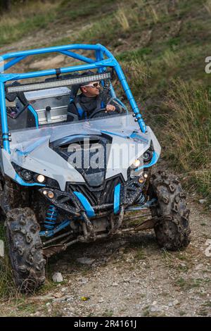 Guida avventurosa di moto ATV. Un uomo guida un quad su strade pericolose Foto Stock