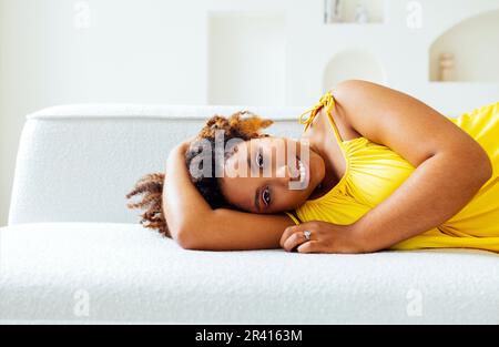 Bella curvy oversize giovane afto donna americana in un abito giallo Foto Stock