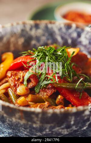 Pilaf con carne di agnello in piatto grande, piatto di insalata di pomodoro e piatto con verdure e verdure Foto Stock