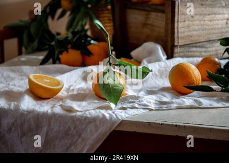 Tabella con box di arancia fresca con orange ramo di albero e succo d'arancia fresco Foto Stock