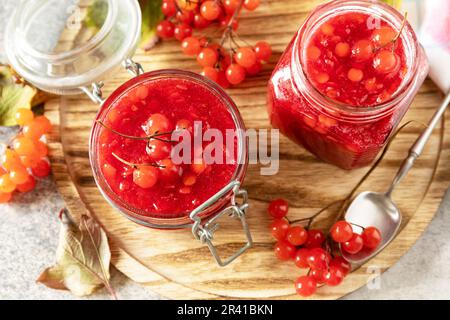 Bacca di viburno fresca matura con zucchero per la preparazione di vitamina e tè antiossidante su un tavolo di pietra. Fonte di vitamine naturali. U Foto Stock