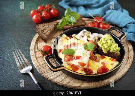 Omelette o omelette con peperoni dolci e pomodori, pane tostato con avocado e frutti di mare salati. Dieta sana cheto basso carb bre Foto Stock