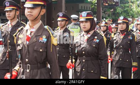 Studenti indonesiani di scuola superiore con uniformi in marcia Foto Stock