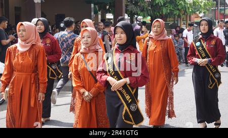 Studenti indonesiani di scuola superiore con uniformi in marcia Foto Stock