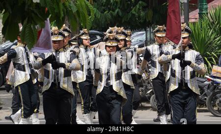 Studenti indonesiani di scuola superiore con uniformi in marcia Foto Stock