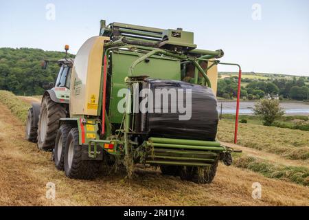 Timoleague, West Cork, Irlanda. 25th maggio, 2023.Timoleague, West Cork, Irlanda. Il giorno più caldo dell'anno, Richard McCarthy, che coltiva latticini con il fratello Michael, balla l'insilato nella sua fattoria a Timoleague, West Cork. Richard utilizza un trattore Deutz-Fahr Agrotron K610 e un'imballatrice Krone Comprina CF 155 XC. Credit: AG News/Alamy Live News Foto Stock