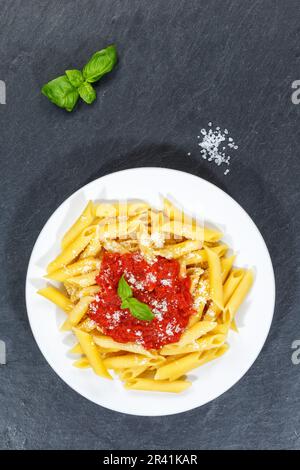 Penne Rigatoni Rigate pasta italiana in salsa di pomodoro mangiare piatto pranzo su piatto ardesia ritratto dall'alto a Stoccarda, Germania Foto Stock