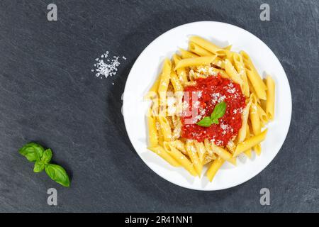 Penne Rigatoni Rigate pasta italiana in salsa di pomodoro mangiare piatto pranzo su piatto ardesia dall'alto a Stoccarda, Germania Foto Stock