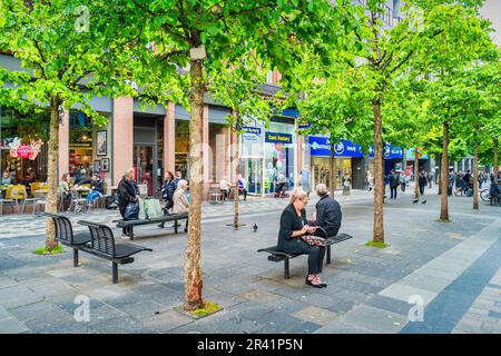 La gente si rilassa nel quartiere dello shopping di Sauchiehall Street nel centro di Glasgow, Scozia, Regno Unito Foto Stock