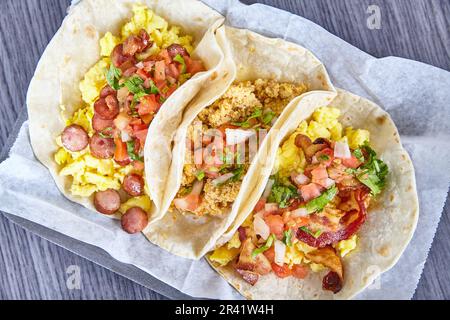 Tre tacos ispanici colazione pancetta salsiccia chorizo uova su bianco semplice risorsa sfondo Foto Stock