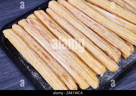 Churros su vassoio nero dolci da forno messicani ricoperti di zucchero alla cannella e a forma di stella Foto Stock