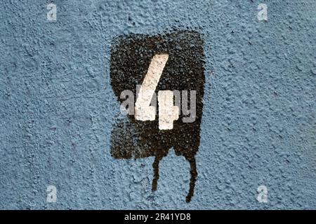 Numero 4 verniciato su una parete blu testurizzata con vernice a gocciolamento Foto Stock