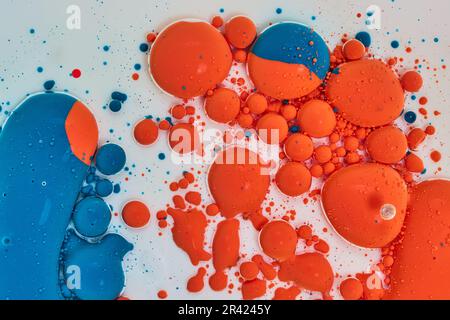Sfere e bolle arancioni e blu che ballano su sfondo bianco Foto Stock