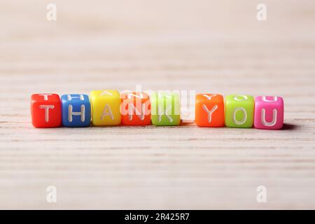 Frase grazie fatto di cubi colorati su un tavolo di legno chiaro Foto Stock