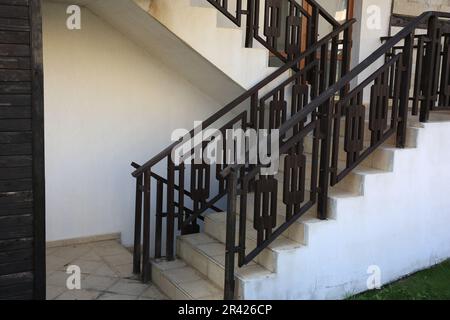 Vista di belle scale con corrimano in metallo vicino casa all'aperto Foto Stock