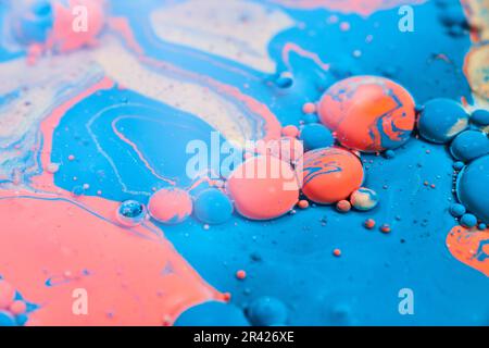 Lucido acrilico astratto versare con olio e un blu palline arancio e swirls dorati in fondo risorsa Foto Stock