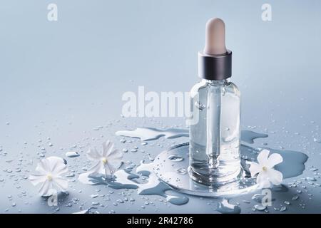 Flacone e vetrino per prodotti cosmetici su sfondo blu. Concetto idratante di cura della pelle Foto Stock