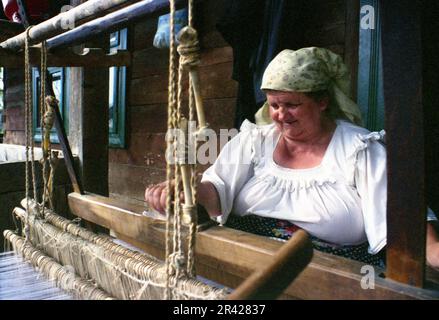 Maramures County, Romania, 2001. Donna tessendo usando un vecchio telaio tradizionale. Foto Stock