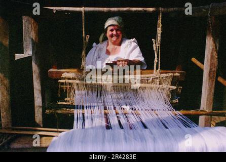 Maramures County, Romania, 2001. Donna tessendo usando un vecchio telaio tradizionale. Foto Stock