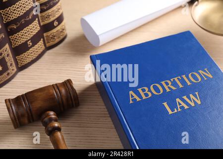 Libro di legge sull'aborto e gavel su tavola di legno Foto Stock