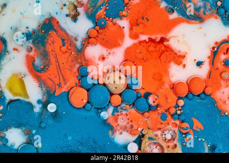 Orizzontale acrilico pour creare pittura astratta con blu arancio e bolle d'olio bianco in fondo latte asset Foto Stock