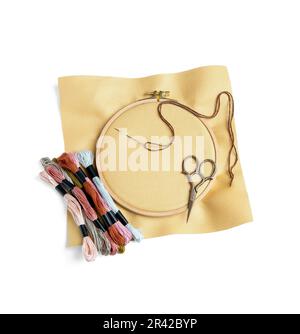 Cerchio in legno ricamato con tela, fili di moulin e forbici isolato su sfondo bianco Foto Stock