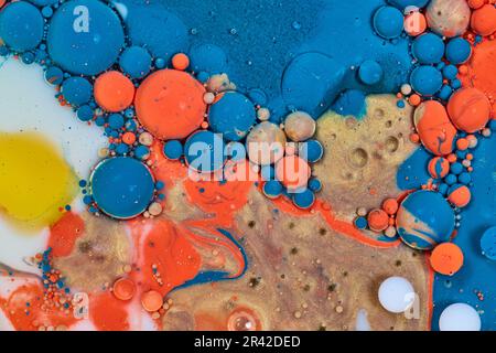 Sfere di oro arancione blu e bianco in mare di pittura acrilica e ad olio vorticosa versare in fondo risorsa astratta Foto Stock