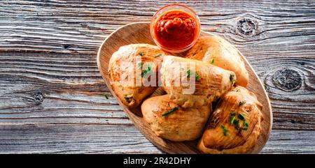 Composizione con un piatto di pierogi al forno Foto Stock