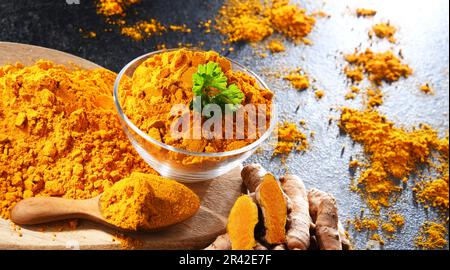 Composizione con una ciotola di curcuma macinato e il suo rizoma fresco. Foto Stock