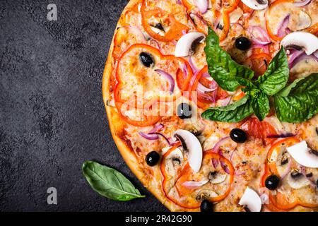 Pizza vegetariana con funghi e olive su sfondo nero primo piano Foto Stock