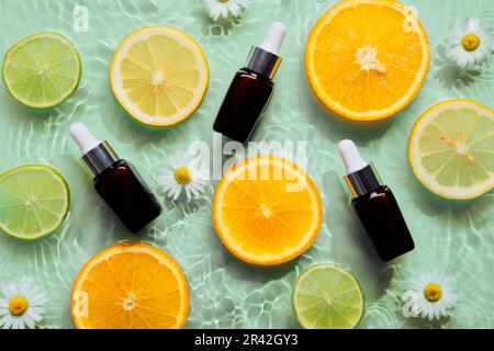 Bellezza sfondo con prodotti cosmetici biologici bottiglie, agrumi, cerchi concentrici e increspature Foto Stock