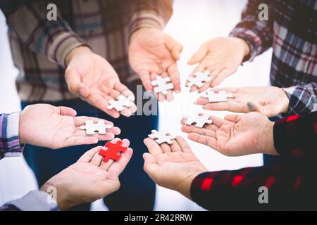 Il team aziendale sta collegando pezzi di puzzle, unità, cooperazione, lavoro di squadra. Foto Stock