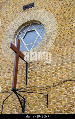 Particolare di una estesa croce cristiana e finestra rotonda con la Stella di David, sulla Chiesa del Porto, principale via dello shopping Whitstable, Inghilterra. Foto Stock