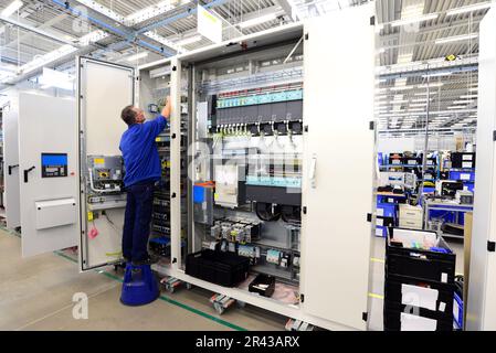 Operatore macchina assembla in una fabbrica - produzione di armadi elettrici per impianto industriale Foto Stock