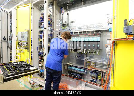 Operatore macchina assembla in una fabbrica - produzione di armadi elettrici per impianto industriale Foto Stock